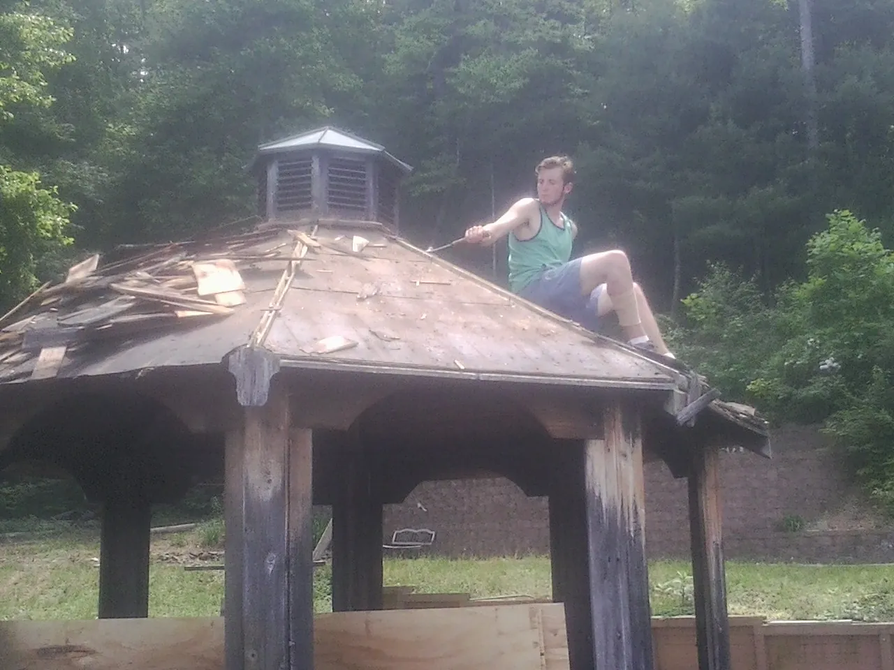 Tearing the old roof off a wooden gazebo before new shakes in Pawlet