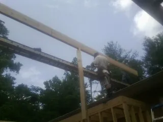 Carpenter setting a ridge beam over a new addition frame — Ice Dam Removal by Roofing Brothers in Pawlet