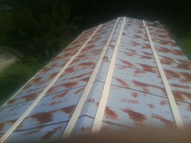 Rusted metal roof panels with new wood purlins before replacement — Storm Damage Roof Repair in Pawlet by Roofing Brothers