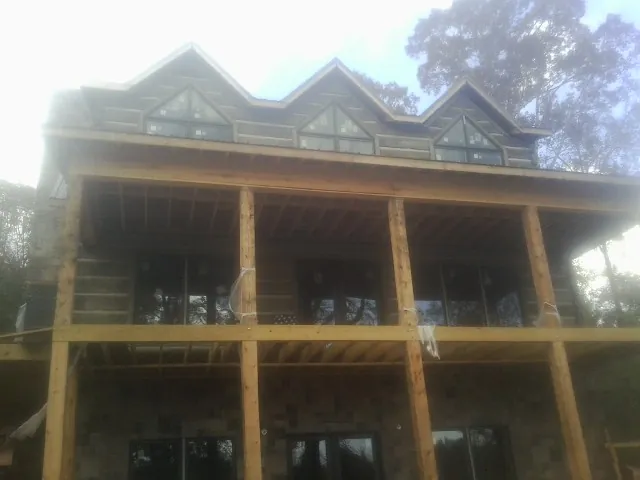 Dormers and porch framing on a large log home under construction — Roof Coating work by our crew in Pawlet