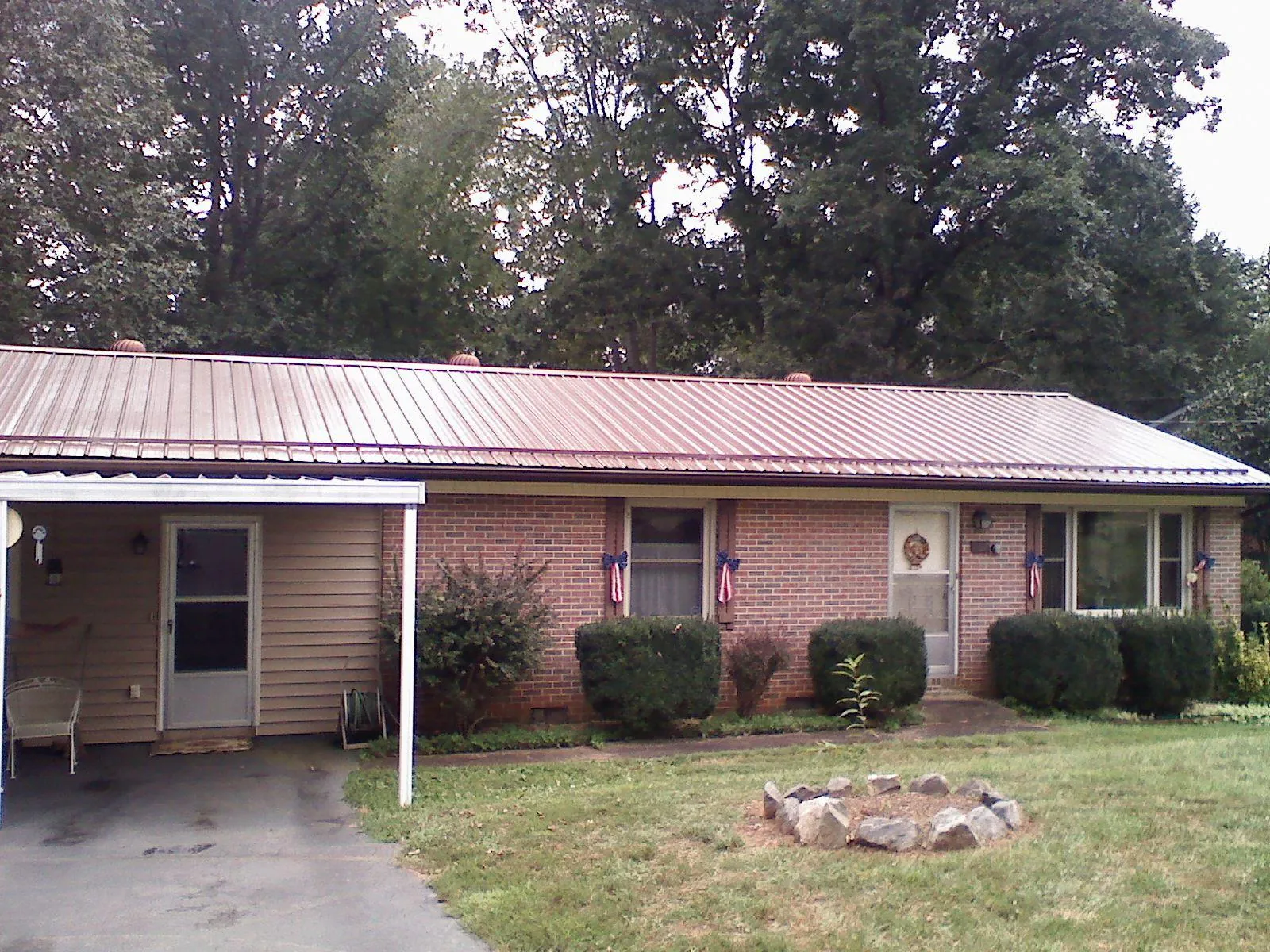 Bronze metal roof and carport on a brick ranch home — Roof Repair work by our crew in Pawlet